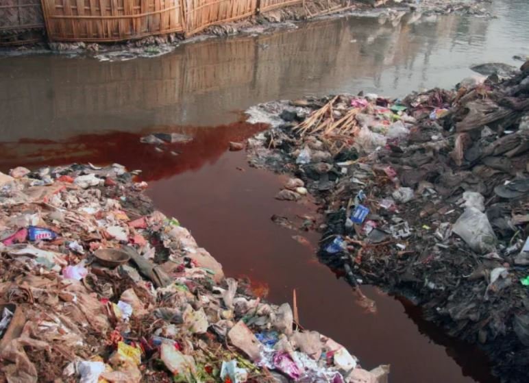 Image of fabric dye being dumped in a river.