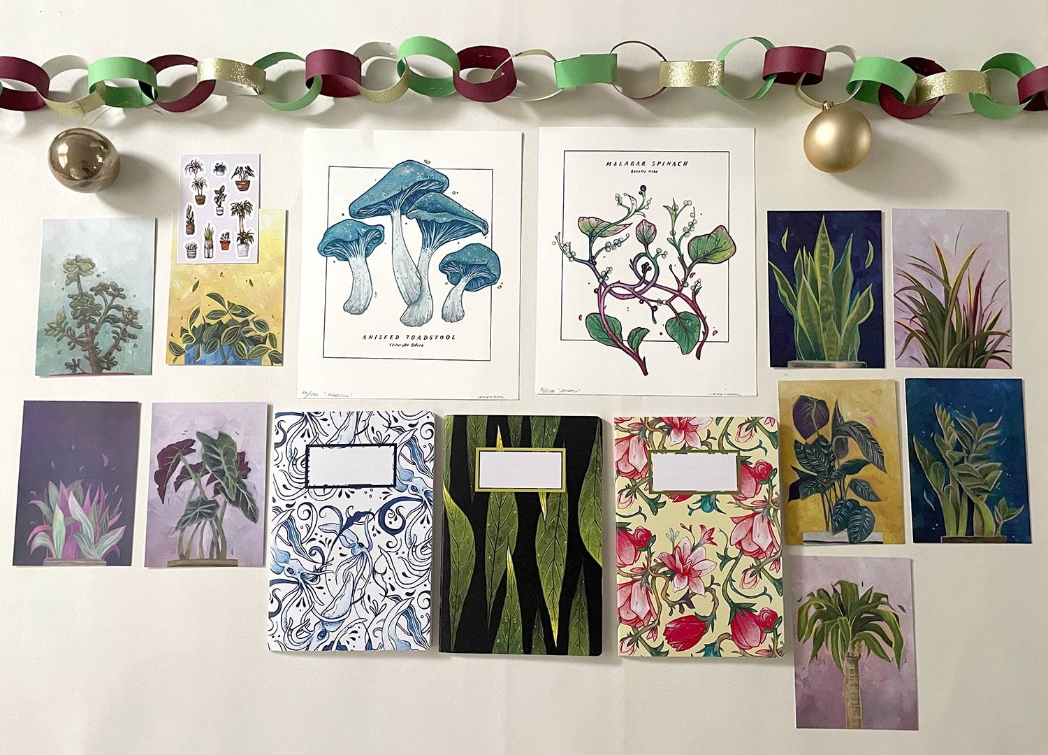 a flat lay of different art, notebooks, postcards and stickers 