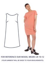 An is wearing a salmon pink shift dress with short sleeves.