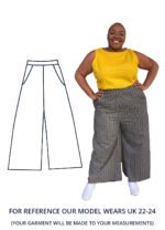 Nyome is wearing a black and white printed pair of wide leg trousers and is looking at the camera smiling with their hands on their hips.